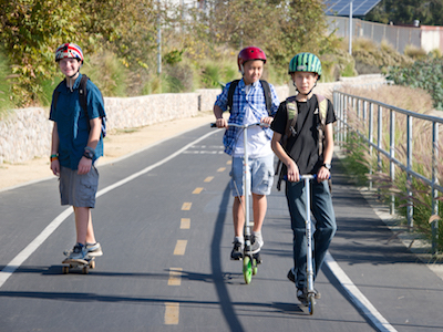 Photo of kids scooting to school, excerpt from the how-to guide for the Safe Routes Partnership